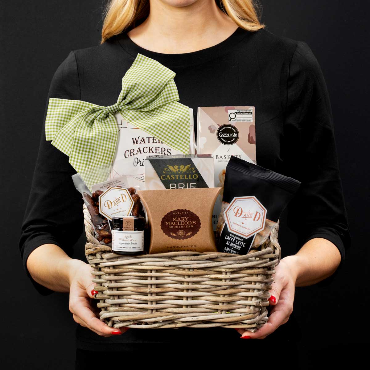 The Stratford gourmet gift basket held by a person in a black shirt to show size and scale.