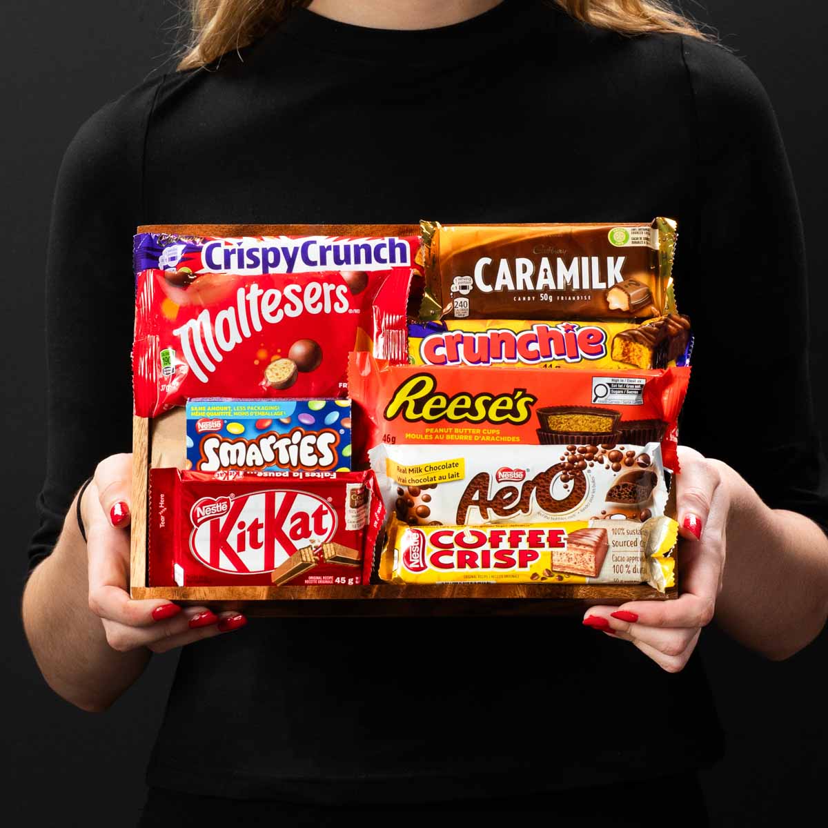 The  Sweet Treats Tray gourmet gift box held by a person in a black shirt to show size and scale.