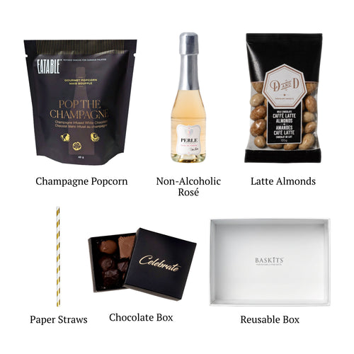 Flat lay of Cheers! Non Alcoholic, showing all 5 items included in the box, including the Non-Alcoholic Sparkling Wine, Champagne Popcorn and container.