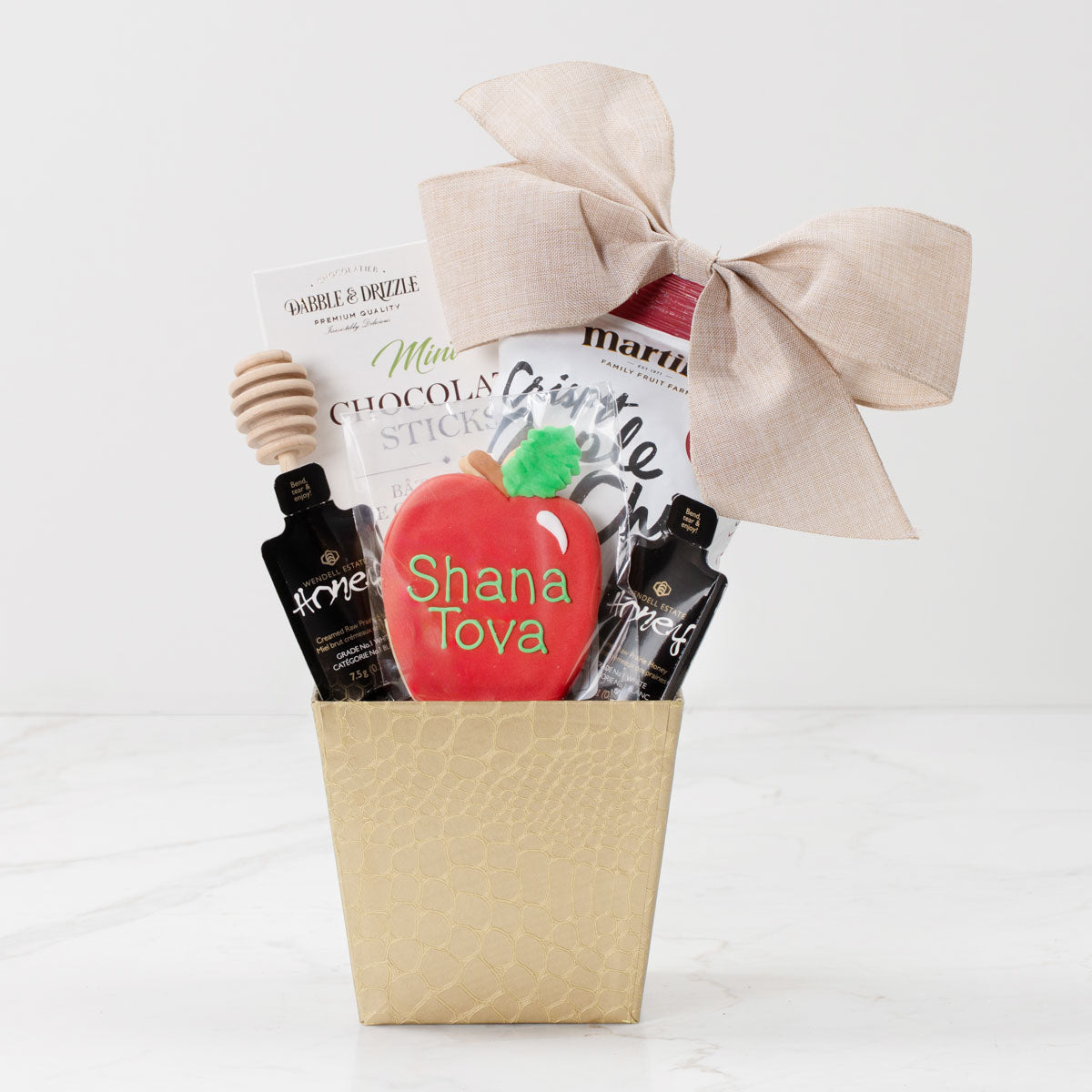 Rosh Hashanah gift basket with gourmet honey, apple chips, a hand-painted apple-shaped cookie and chocolate treats.