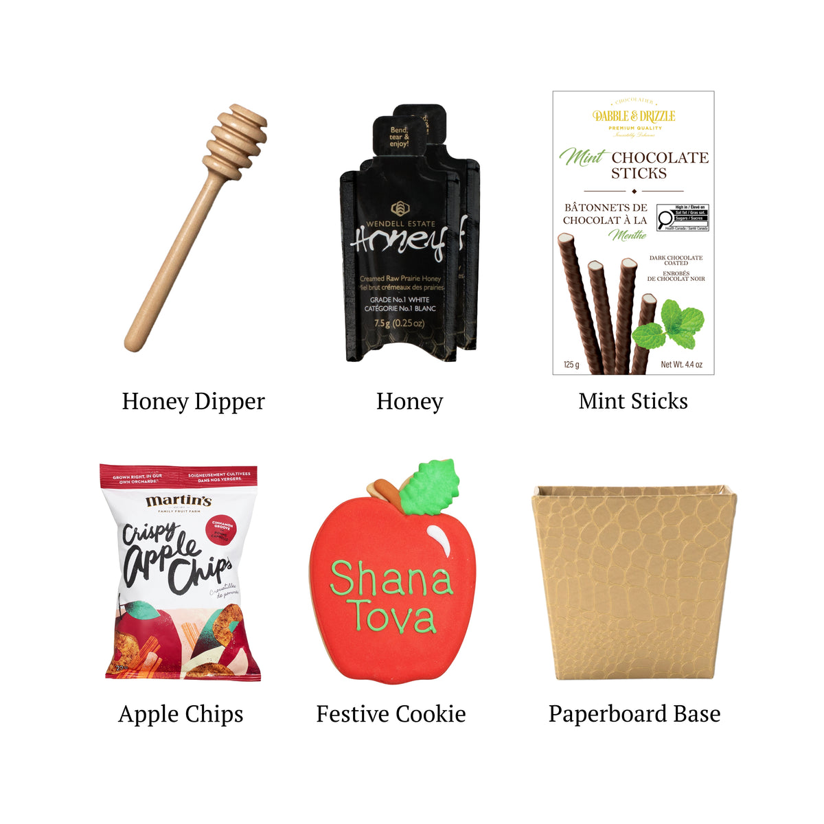 Gilded Orchard flat lay displaying a paperboard base, gourmet honey, mint chocolate sticks, apple chips, and a hand-painted apple-shaped cookie. 