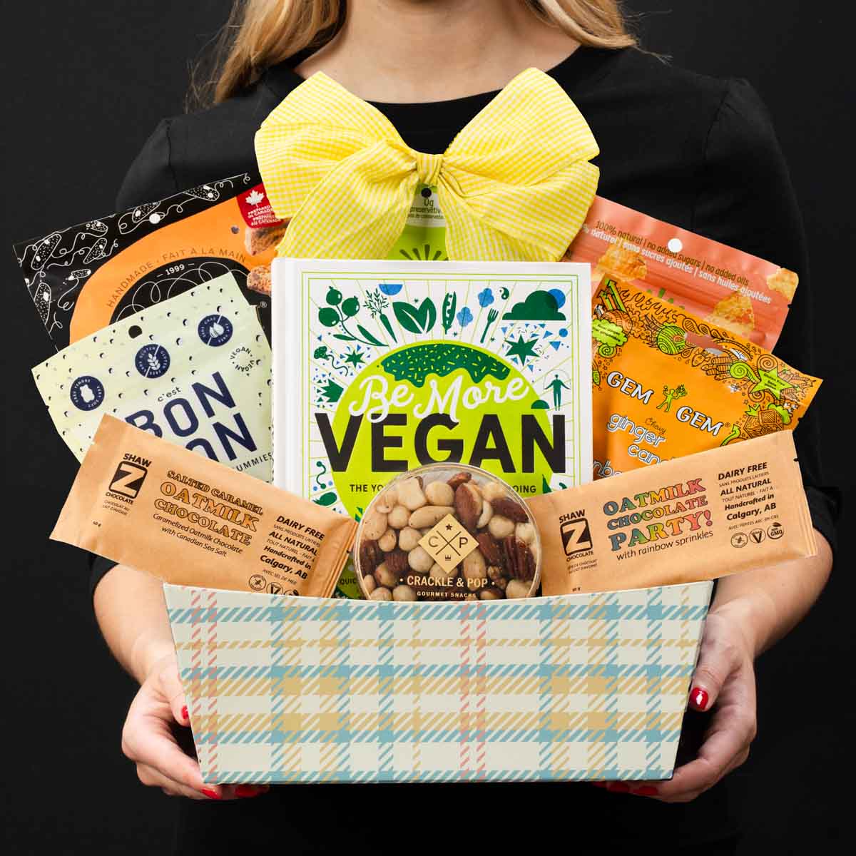 The Vegan gourmet gift basket held by a person in a black shirt to show size and scale.