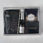 Hands unpacking a 6-piece Cheers Non Alcoholic gift box, displaying a mini bottle of Perle Non-Alcoholic Rosé, and an array of celebratory indulgences.