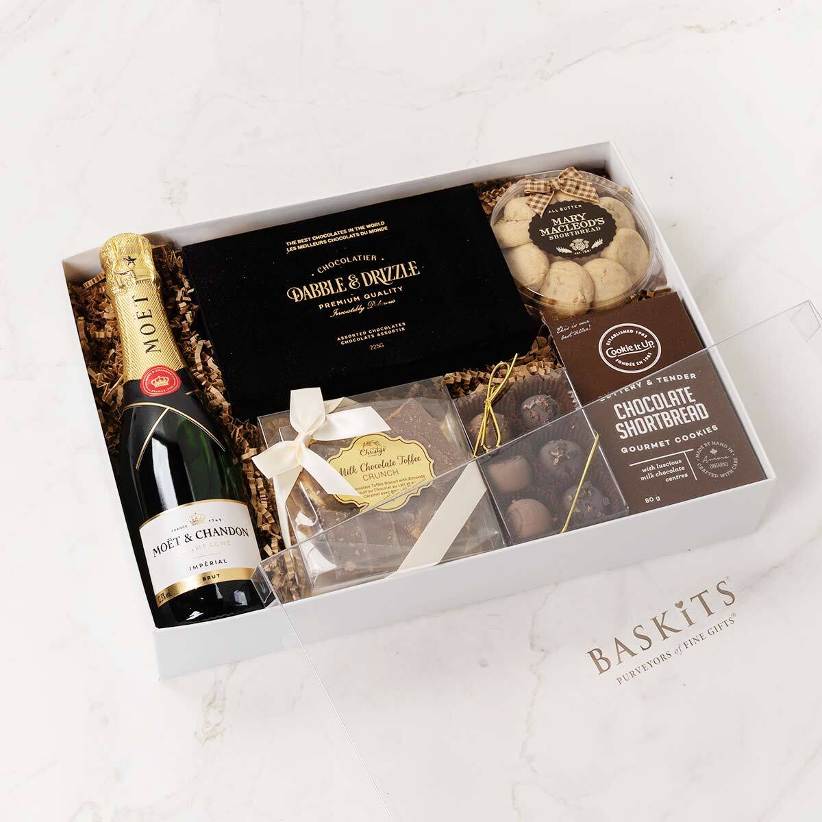 Gift box with sweet treats and a small champagne bottle