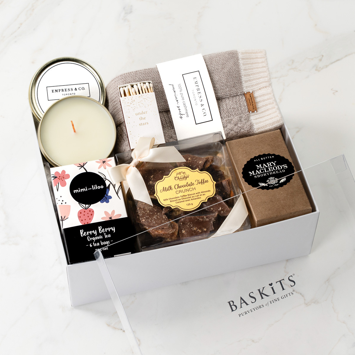 Gift box filled with treats, a candle, and socks